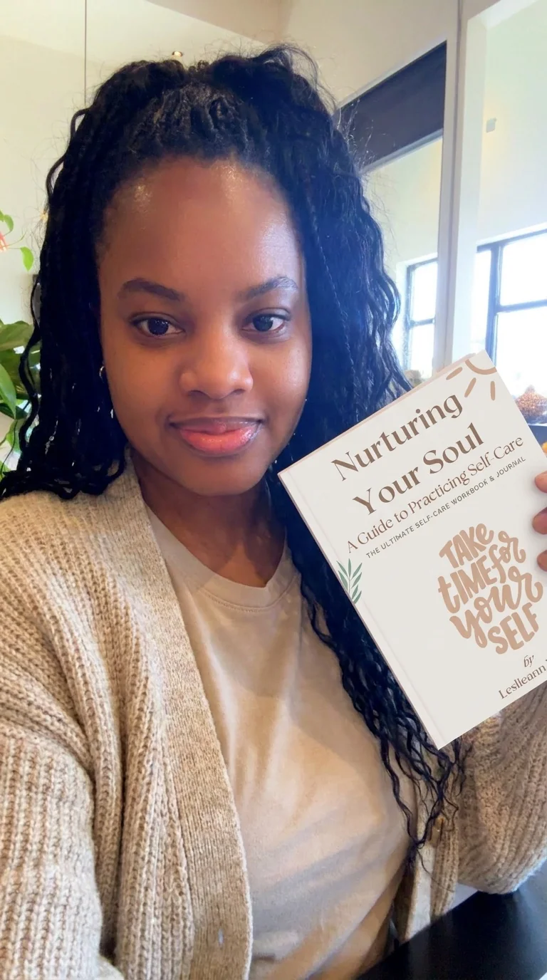 Leslieann smiling and holding up her journal Nurturing Your Soul: A Guide to Practicing Self-Care